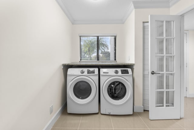 washroom featuring ornamental molding, washer and dryer, and light tile patterned flooring