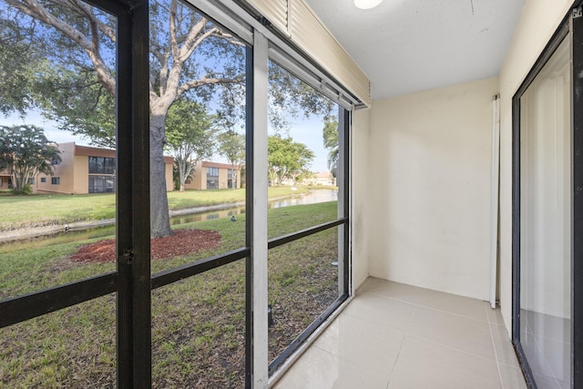 unfurnished sunroom featuring a water view