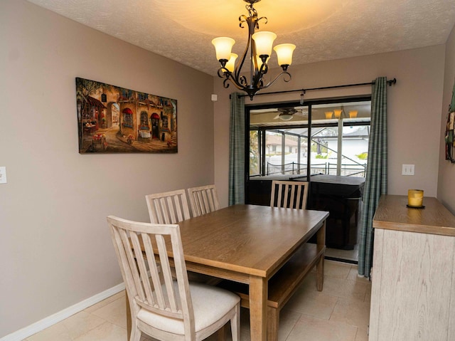 tiled dining space featuring a chandelier and a textured ceiling