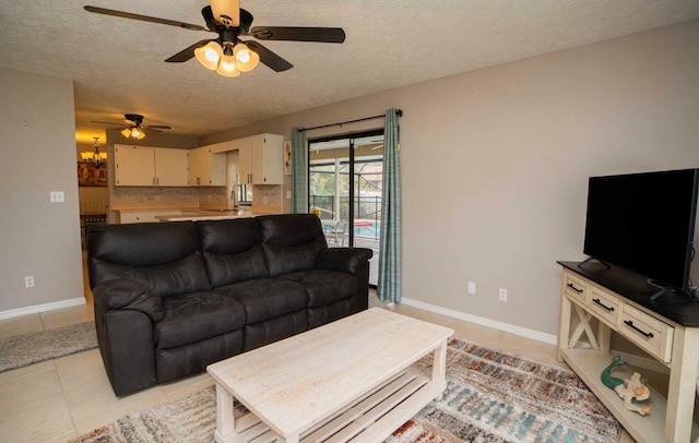 living room with ceiling fan, a textured ceiling, and light tile patterned flooring