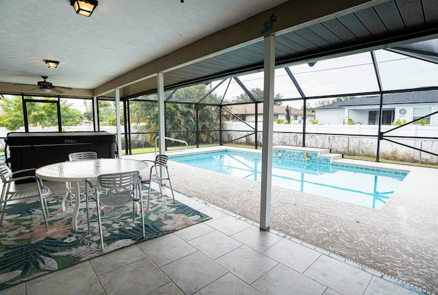 view of swimming pool with ceiling fan, a lanai, a patio area, and a hot tub