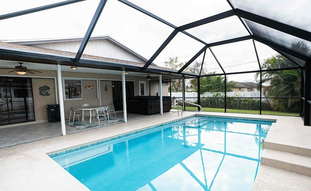 view of swimming pool with a patio area, ceiling fan, and glass enclosure