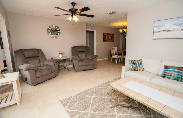 living room with ceiling fan with notable chandelier and a textured ceiling