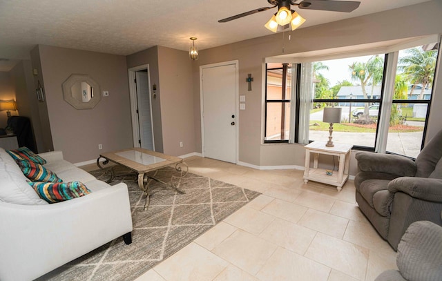 living room featuring light tile patterned floors, a textured ceiling, and ceiling fan