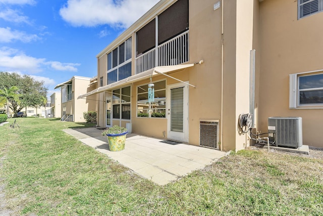 back of property featuring a lawn, central AC, and a patio