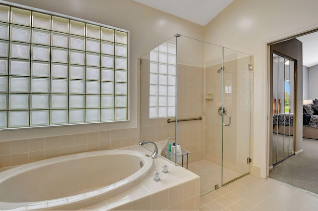 bathroom with tile patterned flooring, a healthy amount of sunlight, and plus walk in shower