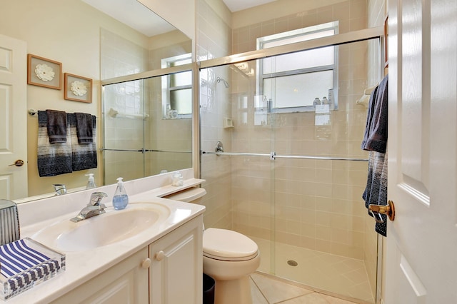 bathroom featuring toilet, vanity, tile patterned flooring, and a shower with shower door