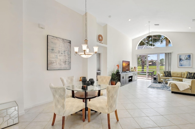 dining area with high vaulted ceiling, an inviting chandelier, and light tile patterned floors