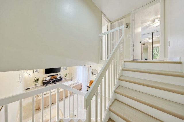 staircase featuring ceiling fan