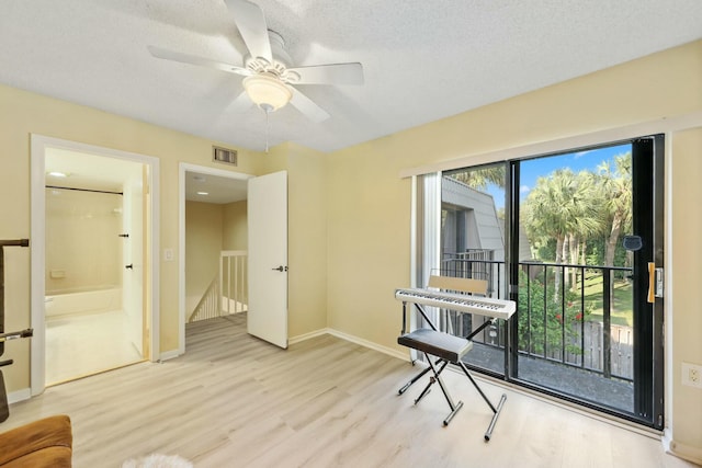 interior space featuring ceiling fan, light hardwood / wood-style flooring, and a textured ceiling