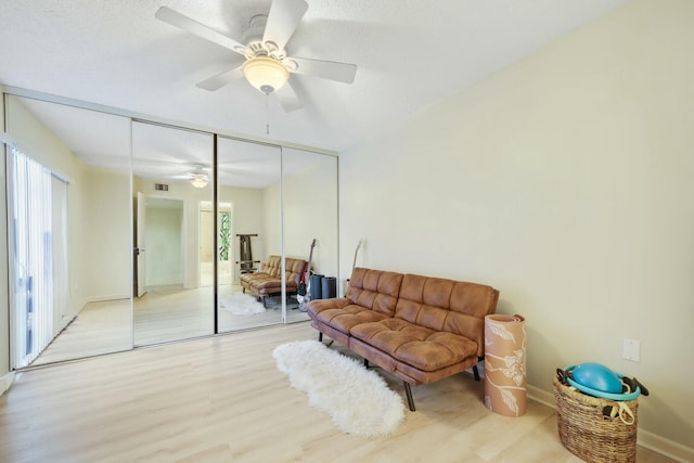 sitting room featuring ceiling fan, a textured ceiling, and light wood-type flooring