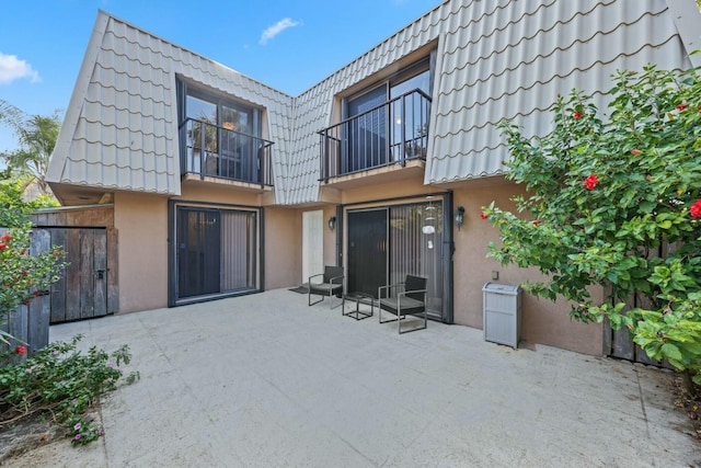 rear view of house with a balcony and a patio