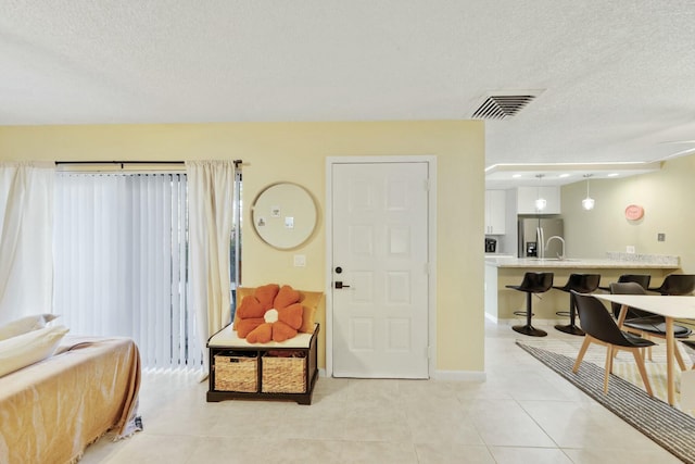 entrance foyer featuring a textured ceiling and light tile patterned floors