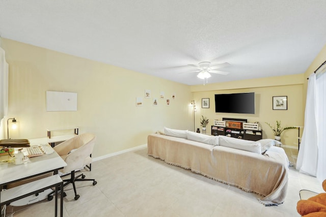 living room featuring ceiling fan and a textured ceiling