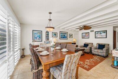 dining room featuring light tile patterned floors, ceiling fan, and beamed ceiling