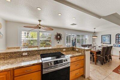 kitchen featuring stainless steel stove, a wealth of natural light, decorative light fixtures, and a textured ceiling