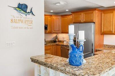 kitchen with light stone counters, appliances with stainless steel finishes, and kitchen peninsula