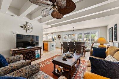 living room with ceiling fan, tile patterned flooring, and beam ceiling