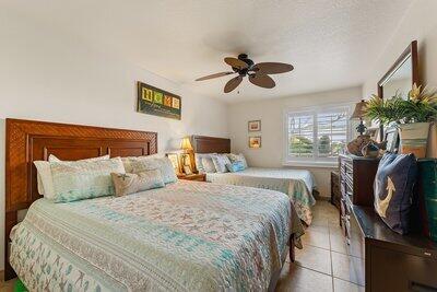 tiled bedroom featuring ceiling fan