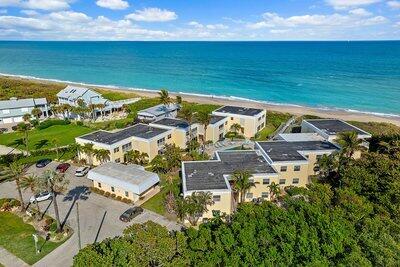 birds eye view of property with a water view and a beach view