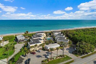 bird's eye view with a water view and a beach view