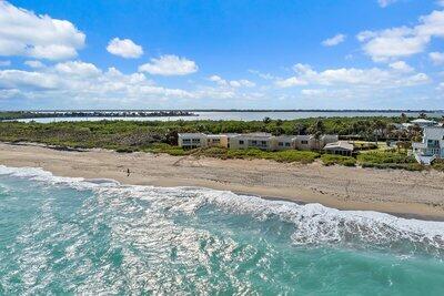 bird's eye view with a water view and a beach view