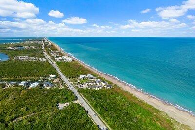 aerial view featuring a water view and a beach view