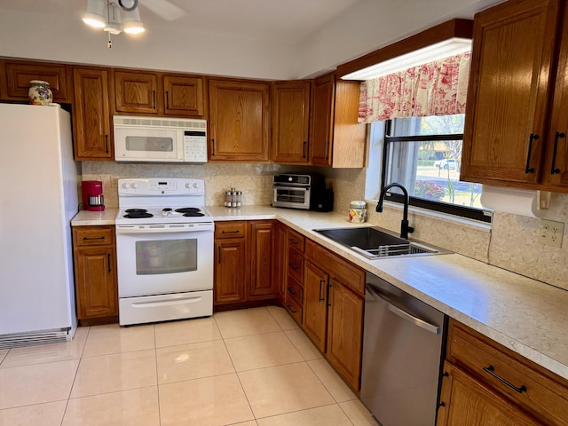 kitchen featuring tasteful backsplash, sink, light tile patterned floors, ceiling fan, and white appliances