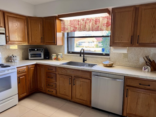 kitchen featuring sink, light tile patterned floors, backsplash, and white appliances