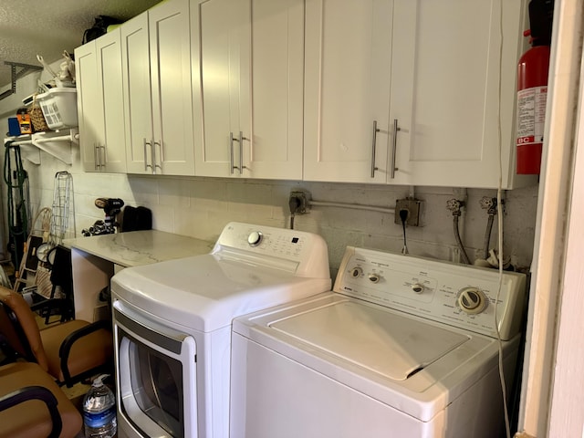 washroom featuring cabinets and washer and dryer