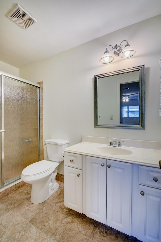 bathroom featuring a shower with door, vanity, and toilet