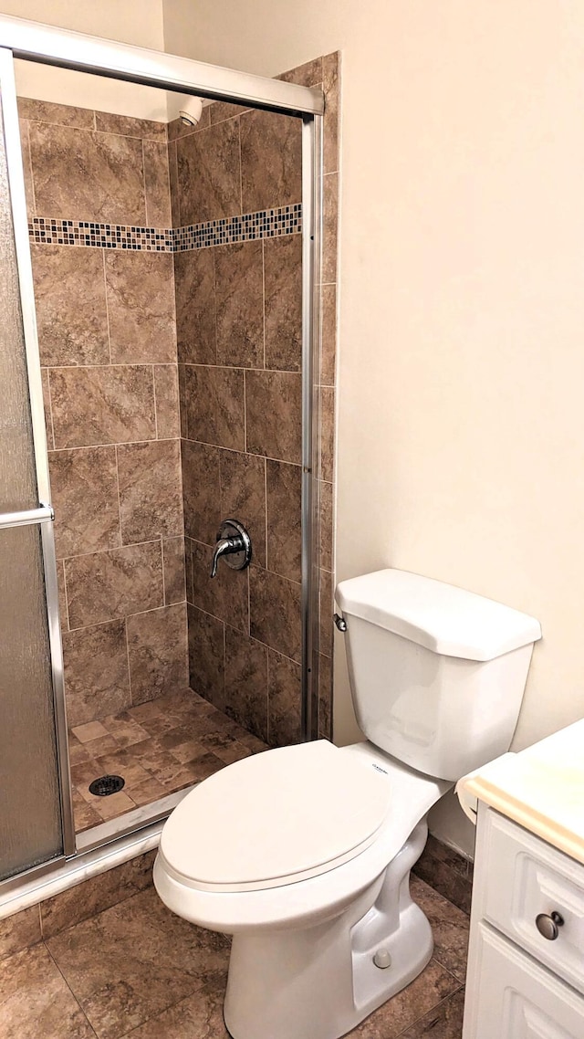 bathroom with toilet, vanity, and walk in shower