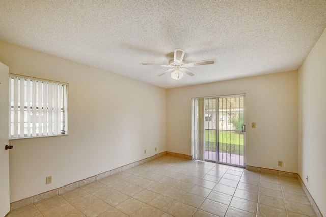 tiled empty room with a textured ceiling and ceiling fan