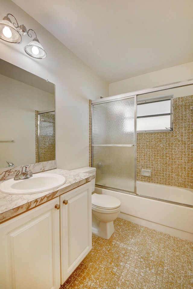 full bathroom featuring vanity, bath / shower combo with glass door, and toilet