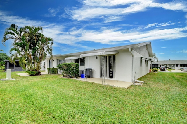 rear view of house with a yard and a patio