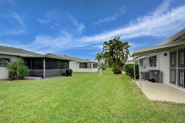 view of yard featuring a sunroom and central AC unit