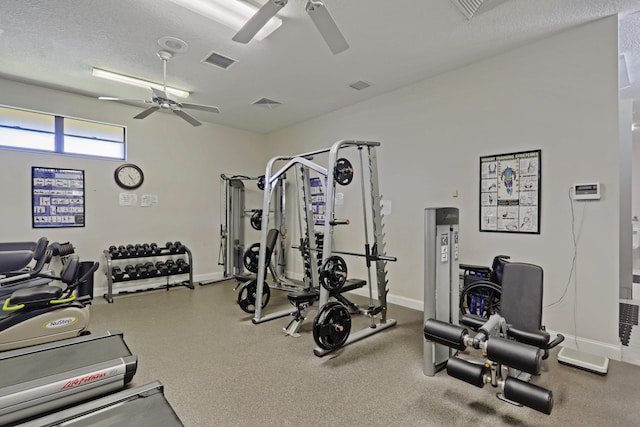 workout area with ceiling fan and a textured ceiling