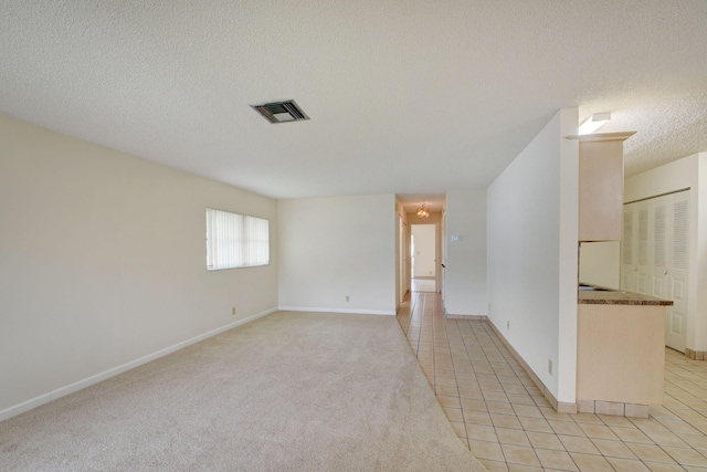 tiled empty room with a textured ceiling