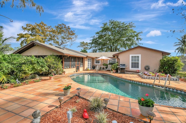 view of swimming pool with a patio area, a sunroom, and area for grilling