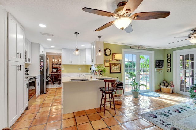 kitchen featuring appliances with stainless steel finishes, white cabinetry, kitchen peninsula, and sink