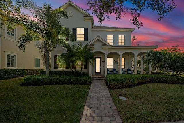 mediterranean / spanish-style house featuring a porch and a yard