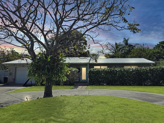 view of front of house with a garage and a yard