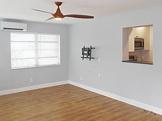 empty room featuring ceiling fan, hardwood / wood-style floors, and a wall unit AC