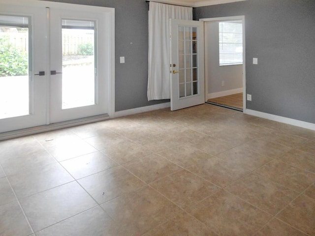 tiled spare room featuring french doors