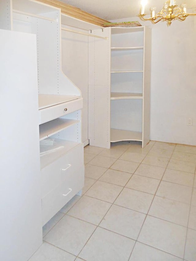 spacious closet featuring light tile patterned flooring and a chandelier