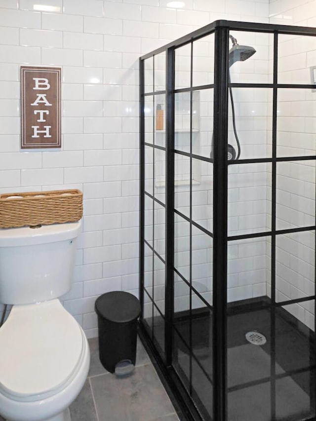 bathroom with tile patterned floors, toilet, and walk in shower