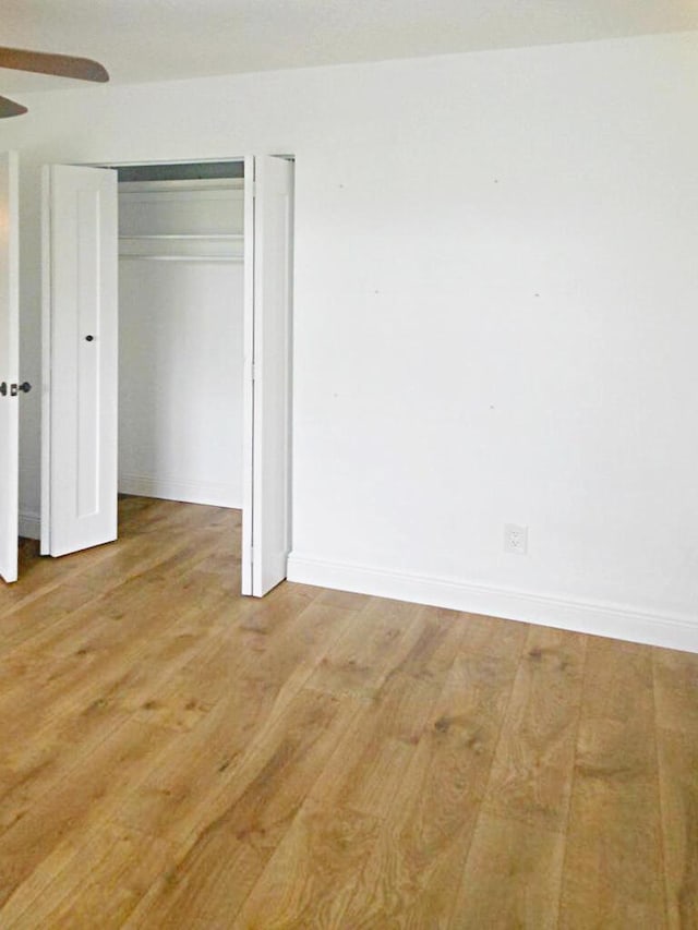 unfurnished bedroom with ceiling fan, light hardwood / wood-style floors, and a closet