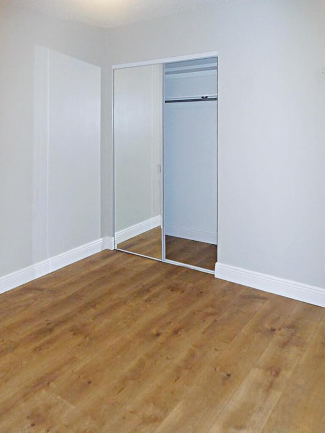 unfurnished bedroom featuring hardwood / wood-style flooring and a closet