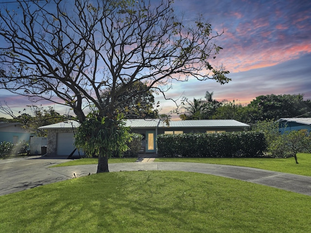 view of front facade featuring a garage and a lawn