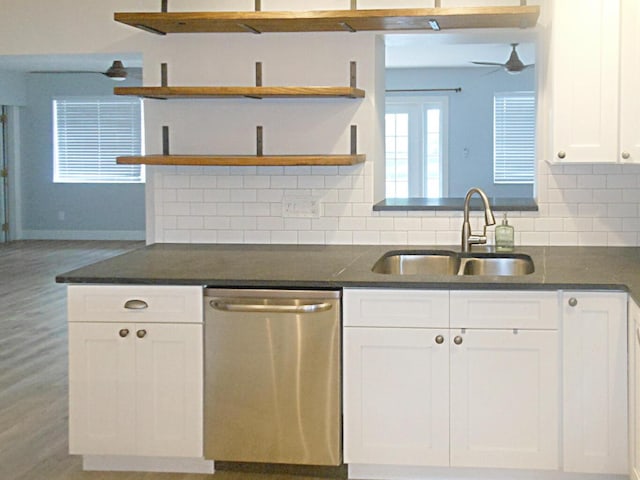 kitchen featuring white cabinetry, sink, dark stone countertops, decorative backsplash, and stainless steel dishwasher